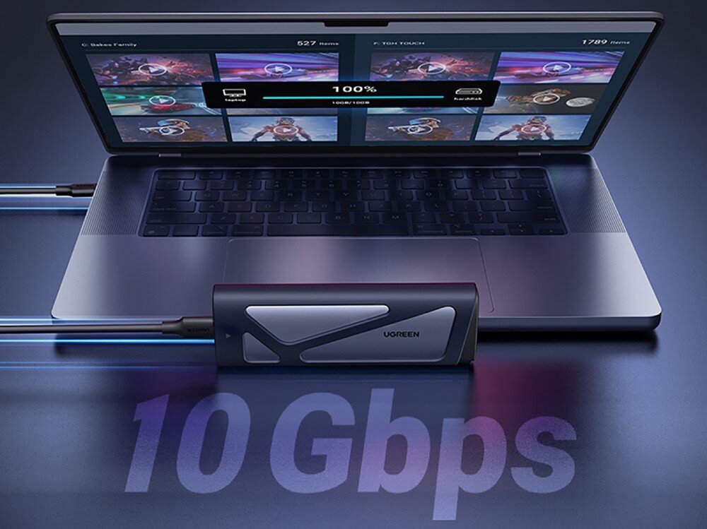 Obudowa dysku UGREEN CM767 Szara obudowa podłączona kablem do otwartego laptopa. Na ekranie komputera widoczny jest pasek postępu kopiowania danych wskazujący 100%. Na pierwszym planie umieszczono duży napis 10 Gbps informujący o prędkości transferu
