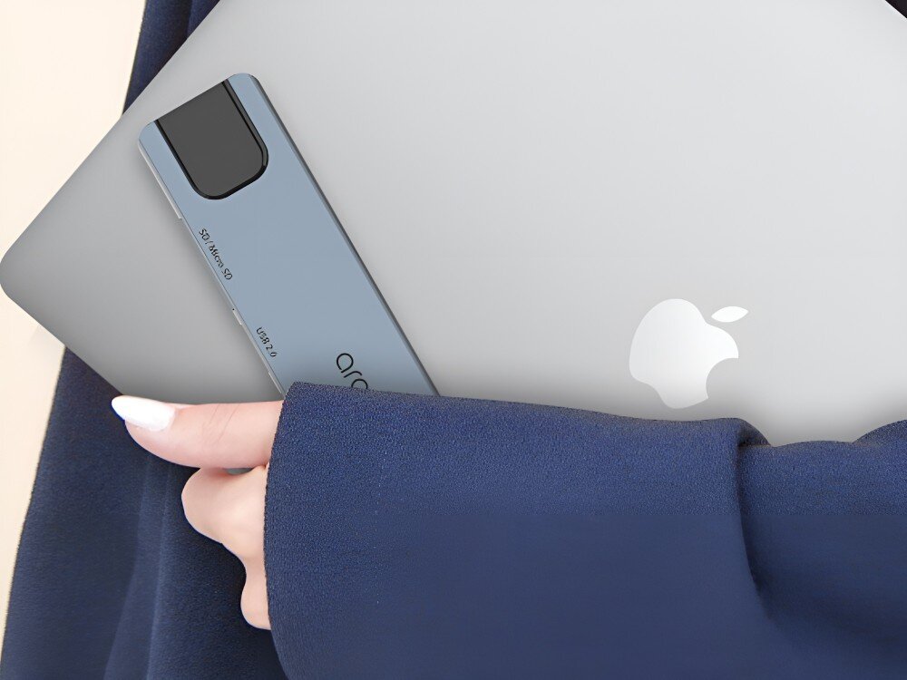 Hub ARAREE AM81 8w1 Osoba w granatowym rękawie trzyma pod pachą laptopa z widocznym logiem producenta. Do laptopa przylega hub USB-C, 
            hub obudowa konstrukcja aluminium kształt ergonomiczny wygoda