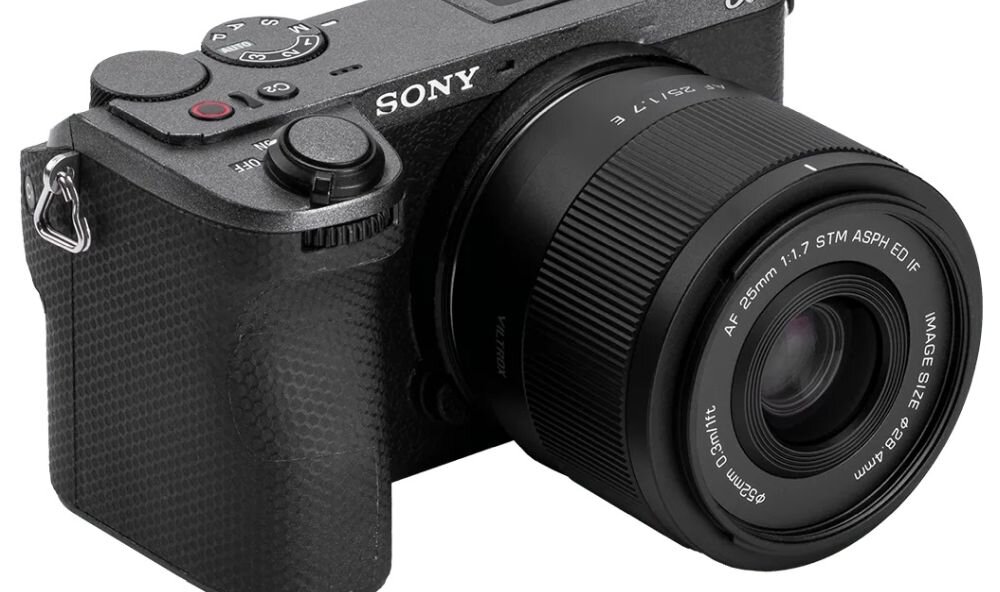 Aparat fotograficzny z zamontowanym obiektywem VILTROX AF 25mm f/1.7 Sony E. Na obiektywie widoczny jest napis: \'AF 25mm 1:1.7 STM ASPH ED IF\'.