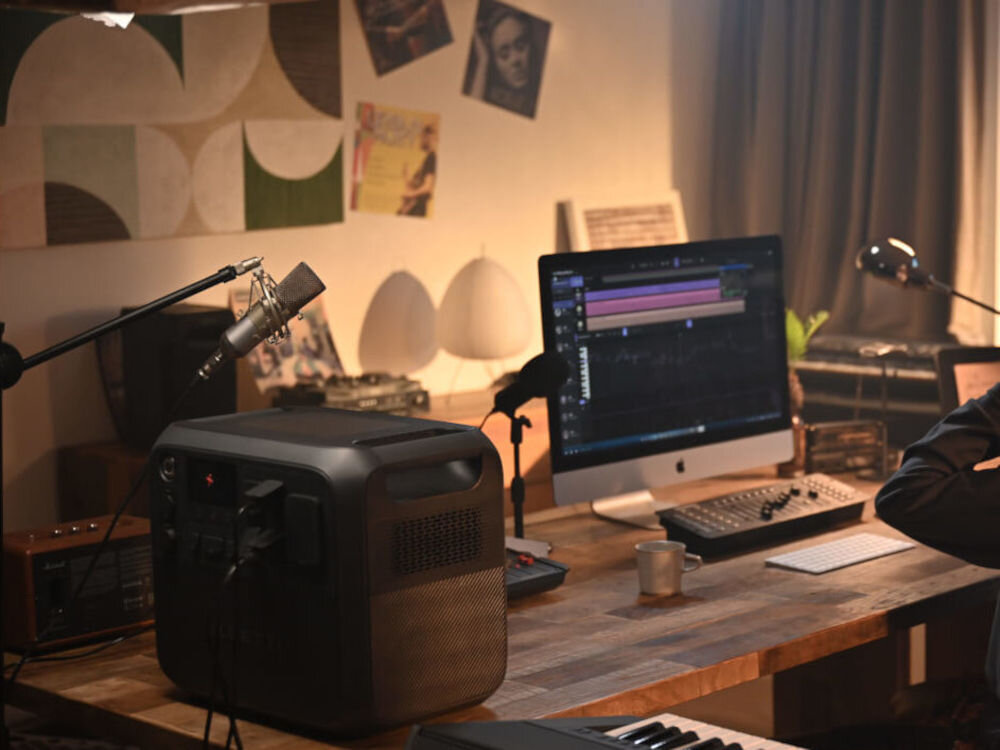 Stacja zasilania BLUETTI AC200PL 2304 Wh Bank energii, przenoszenie, korpus, odpornośc, uderzenia, stacja stoi na biurku w tle studio nagraniowe