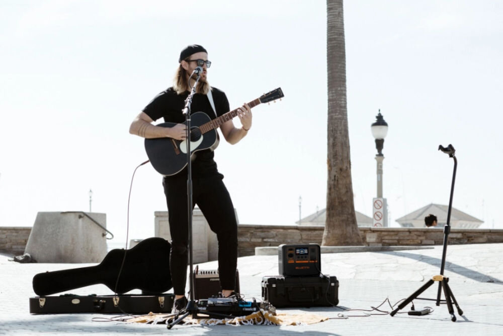 Stacja zasilania BLUETTI AC70P 864 Wh Bank energii, energia, oszczędność, zasilanie, awaryjne, mężcyzna gra na gitarze obok stacja zasilania