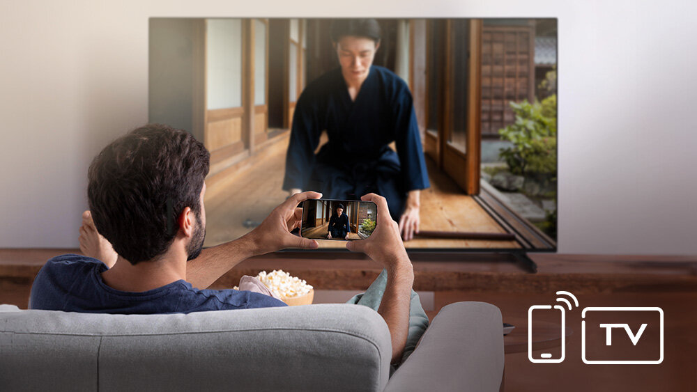 Telewizor JVC LT-43VD3500 - Udostępnianie treści z telefonu, mężczyzna trzyma smartfona w ręku, który przesyła obraz do telewizora