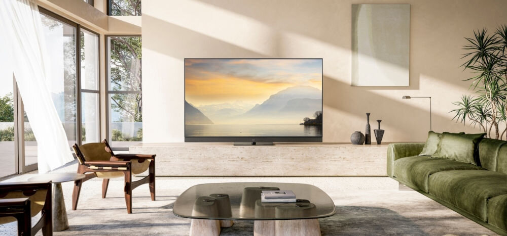 Telewizor PANASONIC TV77Z93AEG OLED Fire TV świat rozrywki, telewizor stojący na komodzie w słonecznym pomieszczeniu