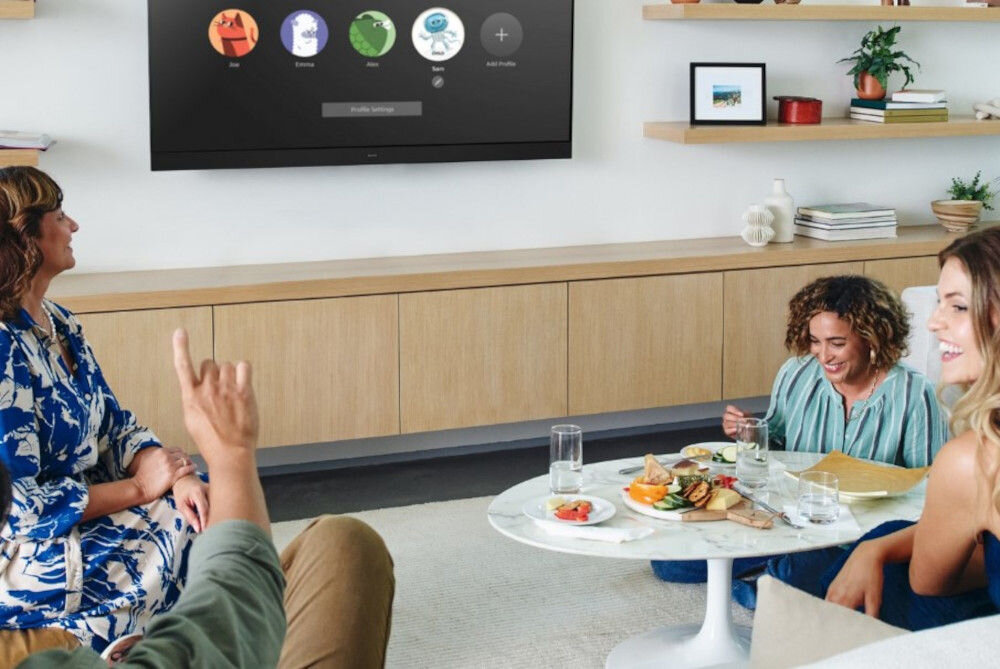 Telewizor PANASONIC TV77Z93AEG profile użytkowników personalizacja, osoby siedzące w salonie, telewizor zawieszony na ścianie