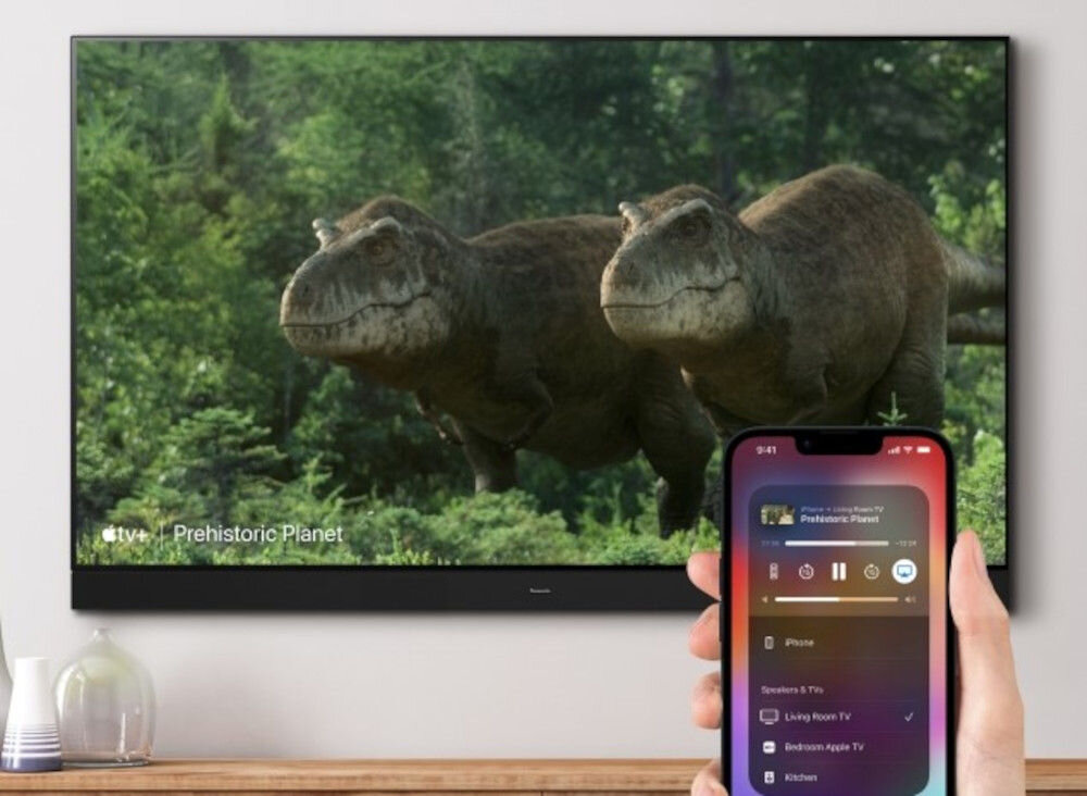 Telewizor PANASONIC TV77Z93AEG AirPlay udostępnianie zdjęcia filmy muzyka, telewizor zawieszony na ścianie, smartfon trzymany w ręku