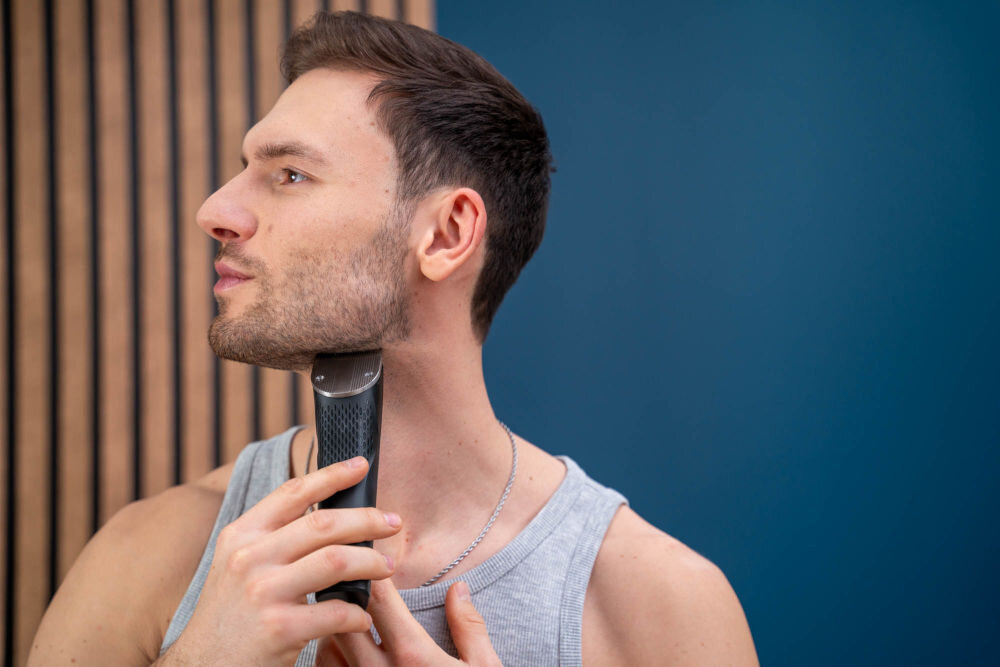 Strzyżarka GÖTZE & JENSEN CL950 Mężczyzna wyrównujący dolną linię zarostu na szyi przy użyciu bezprzewodowej strzyżarki Götze & Jensen.