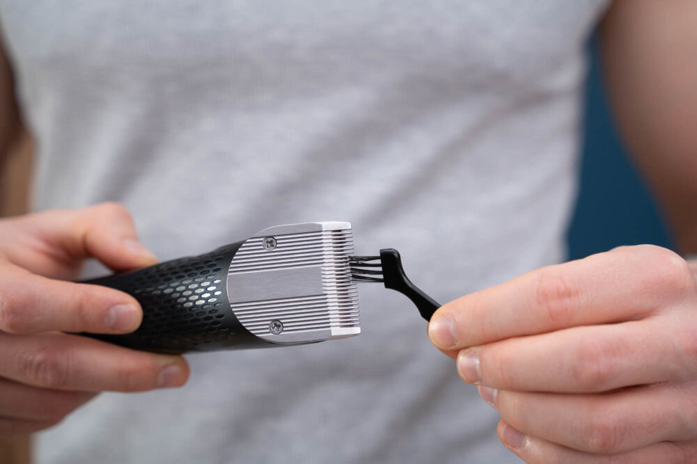 Strzyżarka GÖTZE & JENSEN CL950 Czyszczenie stalowych ostrzy strzyżarki za pomocą małego pędzelka do konserwacji.