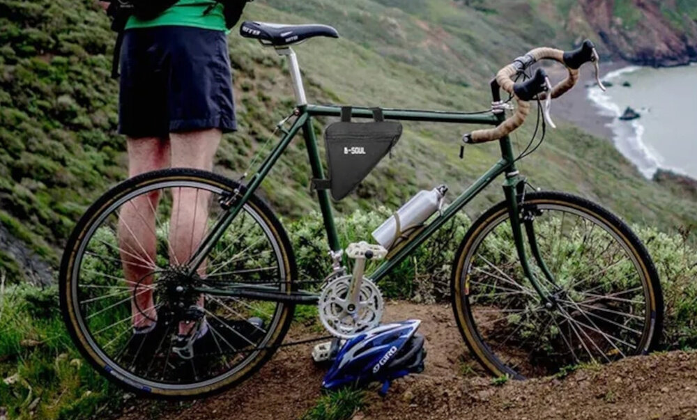 Torba rowerowa na ramę EXTRALINK 14327 góry rower na rowerze umieszczona torba obok stoi osoba miejsce na akcesoria wygoda