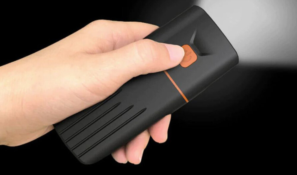 Zestaw lampek rowerowych EXTRALINK 08329 ciemne tło osoba trzyma przednią lampkę w dłoni trzyma palec na przycisku czas działania około 3–4 godzin w zależności od wybranego trybu żywotność diod sięga do 100 000 godzin komfort i bezpieczeństwo