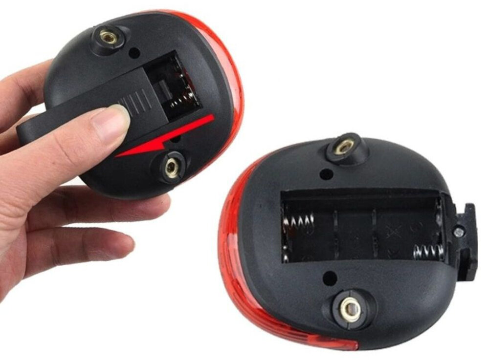 Lampka rowerowa EXTRALINK 14498 lampka w dwóch ujęciach widoczna od tyłu osoba trzyma lampkę w dłoni zasilanie bateryjne 2 x AAA praca nawet do 36 godzin wymiary 70 x 30 x 80 mm prosty montaż do sztycy instalacja zajmuje chwilę