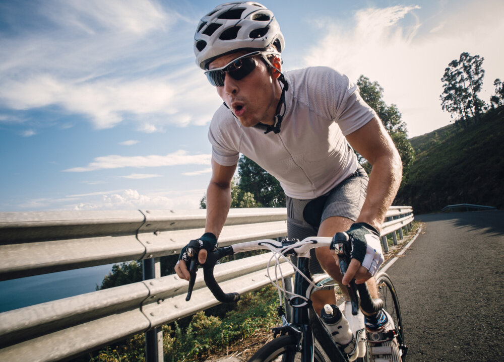 Rower gravel INDIANA Claris M22 28 cali męski Zielony osoba jedzie na rowerze po szosie w tle niebo środek transportu relaks pasja