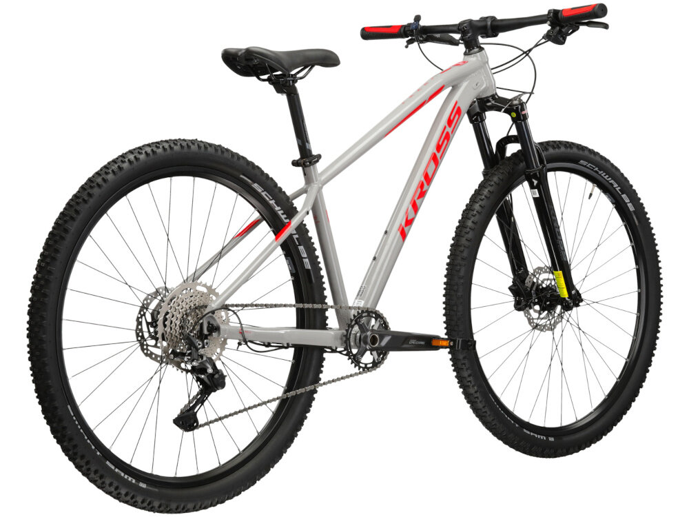 Rower górski MTB KROSS Level 4.0 M16 Guli 29 cali męski Szaro-czerwony rower na białym tle widoczny od tyłu po skosie góral pojazd dla sportowców do jazdy wyczynowej uniwersalny dla amatorów zwrotny łatwo wchodzi w zakręty do jazdy w mieście za miastem w lesie na górskim szlaku w błocie nie za głębokim piachu