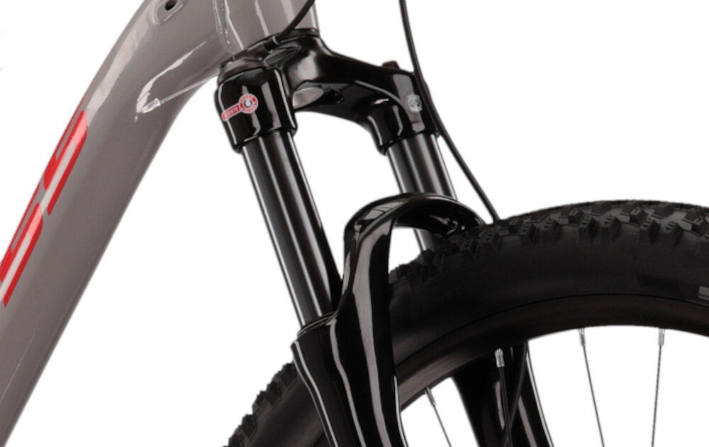 Rower górski MTB KROSS Level 4.0 M17 Guli 29 cali męski Szaro-czerwony zbliżenie na amortyzator rower typu hardtail przedni amortyzator marki SR SUNTOUR typ X1 Coil RL ze skokiem 100 mm ułatwia najeżdżanie na przeszkody niweluje wstrząsy niska masa roweru duża sztywność regulacja za pomocą sprężyny obsługa poprzez pokręteł na goleni