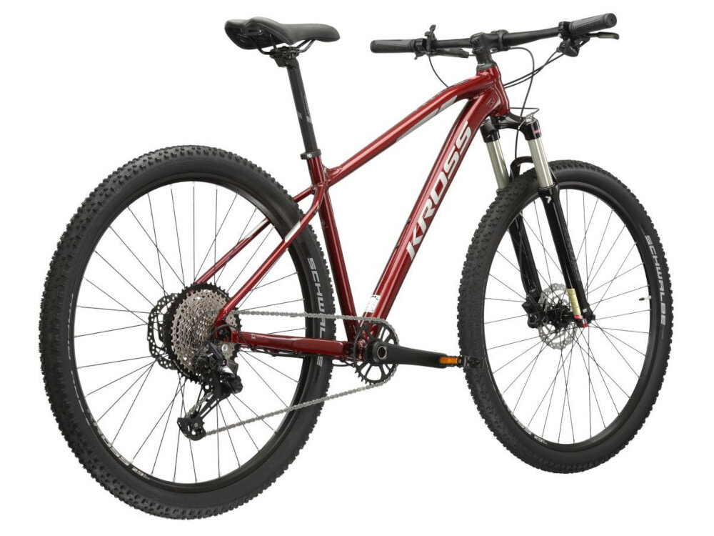 Rower górski MTB KROSS Level 6.0 M17 29 cali męski Rubinowo-srebrny rower na białym tle widoczny od tyłu po skosie góral pojazd dla sportowców do jazdy wyczynowej uniwersalny dla amatorów zwrotny łatwo wchodzi w zakręty do jazdy w mieście za miastem w lesie na górskim szlaku w błocie nie za głębokim piachu