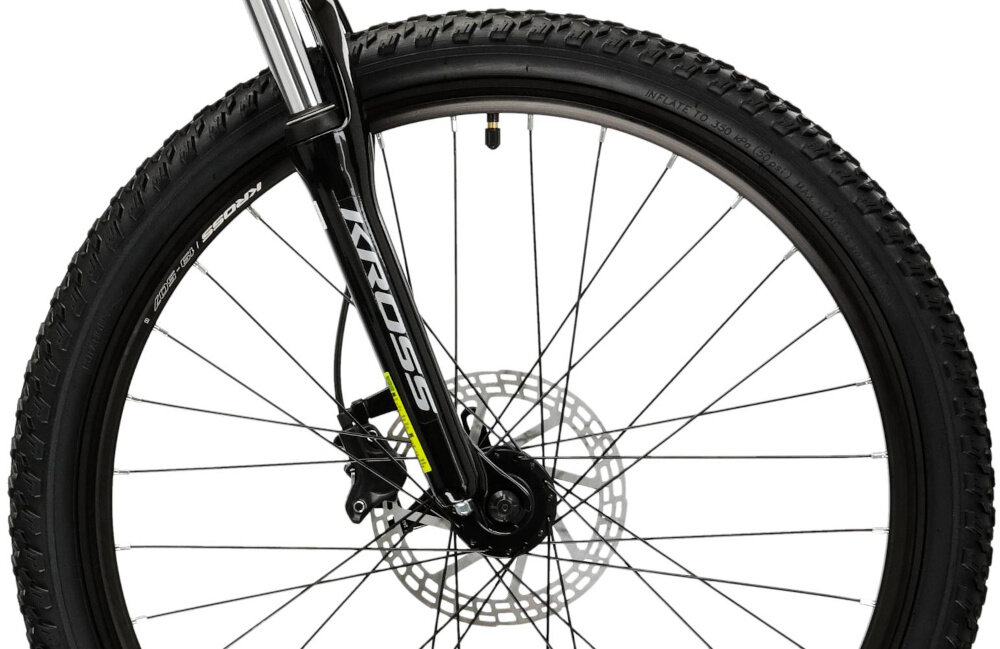Zdjęcie przedstawia przednie koło roweru z widocznym amortyzatorem i tarczą hamulcową. Na widelcu znajduje się napis \'KROSS\'.