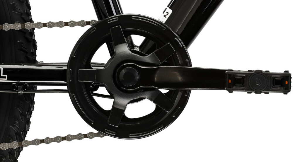 Zbliżenie na mechanizm korbowy czarnego roweru z widocznym łańcuchem i pedałem. Rama roweru jest również czarna z białymi detalami.