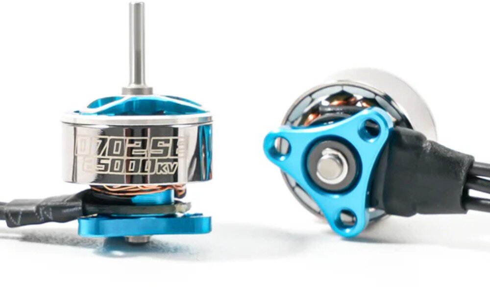 Silnik BETAFPV 0702SE 27000KV (4 szt.) Dwa silniki z niebieskimi detalami na białym tle, gdzie jeden stoi pionowo prezentując na boku grawerunek '0702SE 25000KV', a drugi leży przewrócony eksponując trójkątną podstawę montażową z otworami na śruby