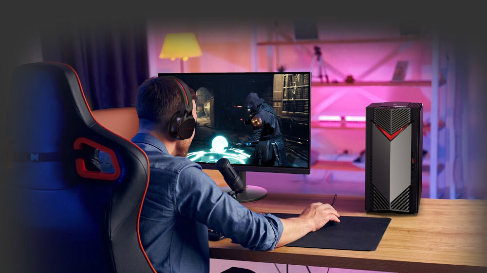 Komputer ACER Nitro N50-656 i5-14400F 32GB RAM 1TB SSD GeForce RTX5060 DLSS 4 Wi-Fi Windows 11 Home mężczyzna grający w grę na komputerze w pokoju w tle regał z różowym podświetleniem led świetna grafika i płynność dzięki RTX i AI szczegółowy obraz