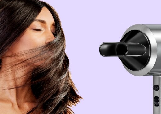 Fragment frontu suszarki do włosów MSW-22z nasadką skupiającą. Obok kobieta z długimi, rozwianymi na twarzy włosami.