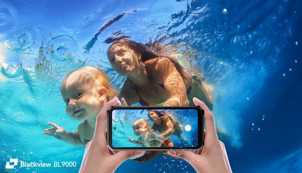Osoba dorosła i dziecko pływają pod wodą, a na pierwszym planie widoczne są dłonie trzymające smartfon, który pokazuje ten sam obraz. W lewym dolnym rogu znajduje się logo \'Blackview BL9000\'.