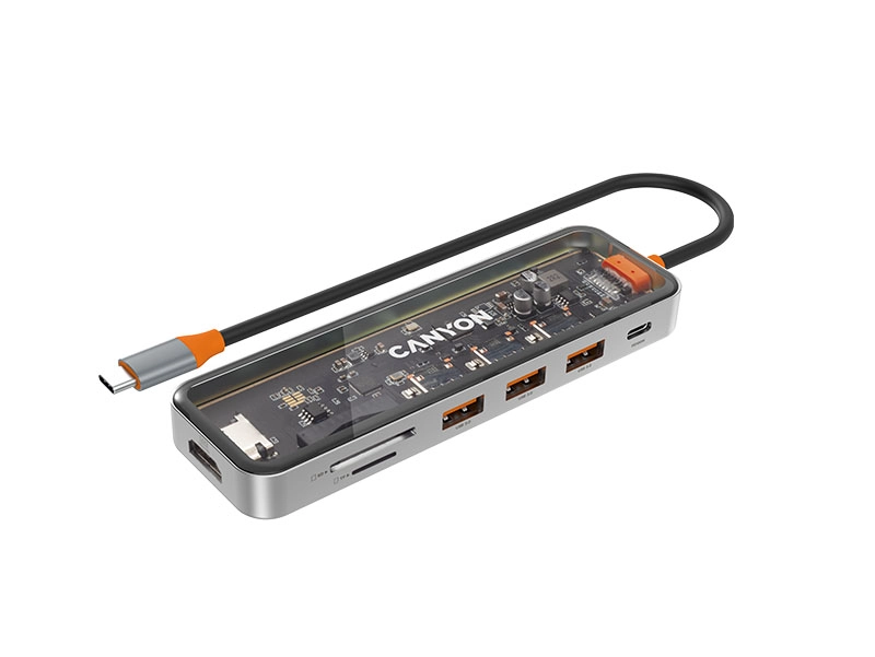 Na obrazie widoczny jest przezroczysty hub USB-C z kilkoma portami, w tym trzema portami USB i jednym HDMI. Na urządzeniu znajduje się logo \'CANYON\'.