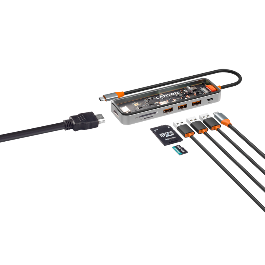 Na obrazie widoczny jest transparentny hub USB-C z napisem \'CANYON\', posiadający kilka portów USB oraz sloty na karty pamięci. Obok znajdują się różne kable i karta microSD z adapterem.