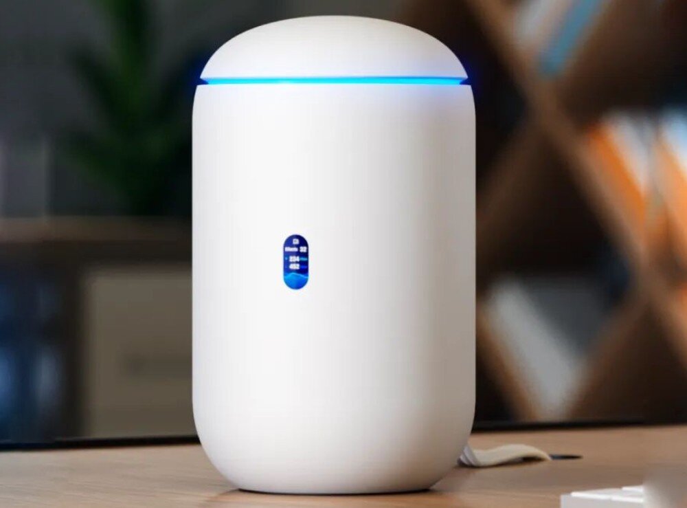 Router UBIQUITI UniFi Dream 7 (UDR7) Zbliżenie na stojący na biurku biały router z widocznym małym wyświetlaczem i świecącym pierścieniem