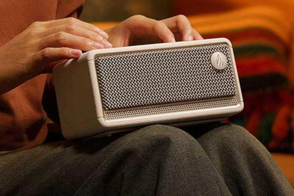 Głośnik mobilny EDIFIER ES60 mikrofon MEMS redukcja szumów rozmowy, osoba trzymająca głośnik na kolanach