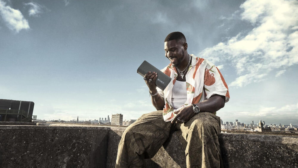 Głośnik mobilny SONY ULT Field 3 osoba siedząca na murku z głośnikiem jakość rozrów echo cancelling eliminacja pogłosu szumu