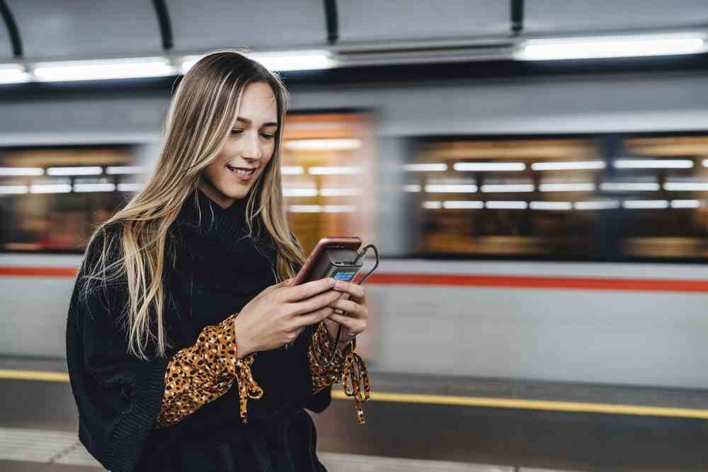 Powerbank CELLULARLINE Ultron 10000 mAh 30W  kobieta w metrze na peronie ładuje smartfon