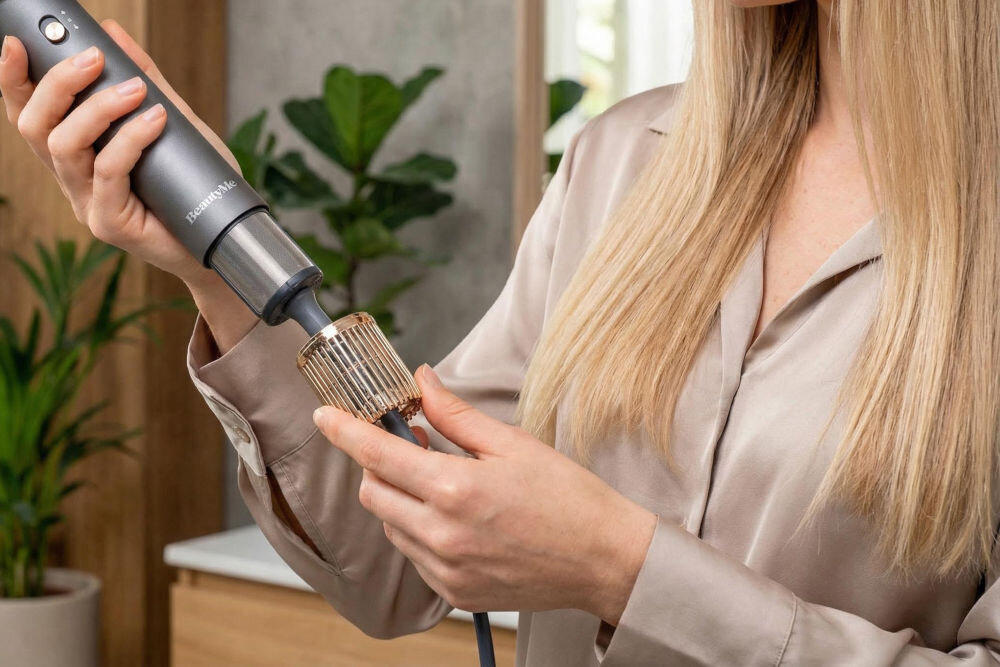 Suszarko-lokówka BEAUTYME AS950 Prezentacja dwukierunkowego systemu obrotowego szczotki Beautyme. Strzałki wskazują możliwość obracania się końcówki w lewo i w prawo, co pozwala na wygodne podkręcanie końcówek do wewnątrz lub na zewnątrz.