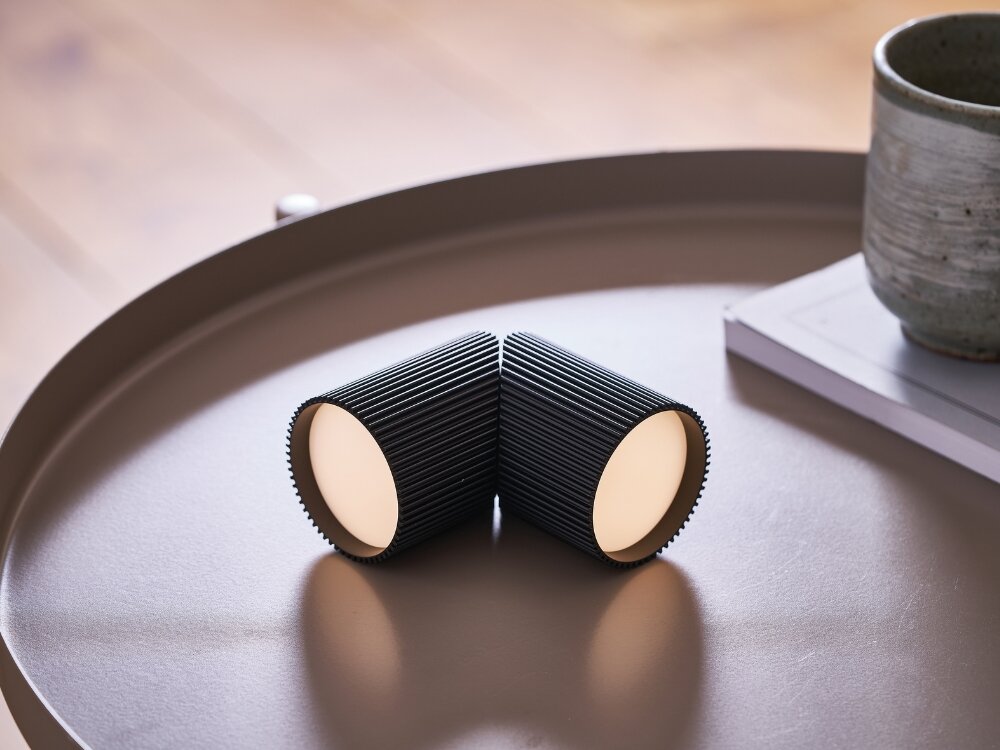 Lampka LEXON Ray Light Czarny (2 szt.) moc w detalu czarne lampki leżą na stoliku żebrowana faktura