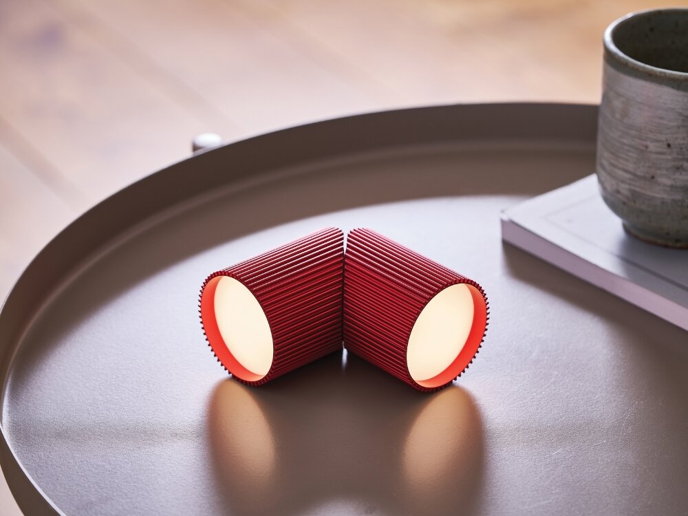 Lampka LEXON Ray Light Czerwony (2 szt.) moc w detalu czerwone lampki leżą na stoliku żebrowana faktura