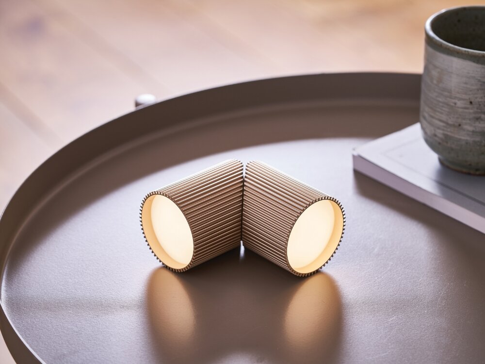 Lampka LEXON Ray Light Złoty (2 szt.) moc w detalu złote lampki leżą na stoliku żebrowana faktura