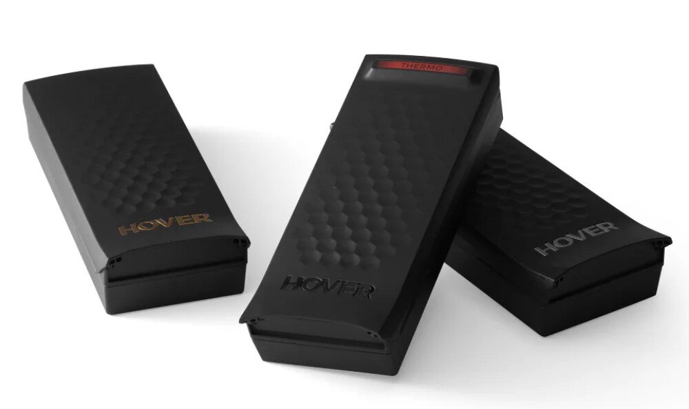 Akumulator HOVERAIR Thermo Smart do X1 Pro / X1 ProMax Kompozycja trzech czarnych urządzeń na białym tle, z których środkowe prezentuje u góry czerwony, podświetlony pasek z tekstem 'THERMO'