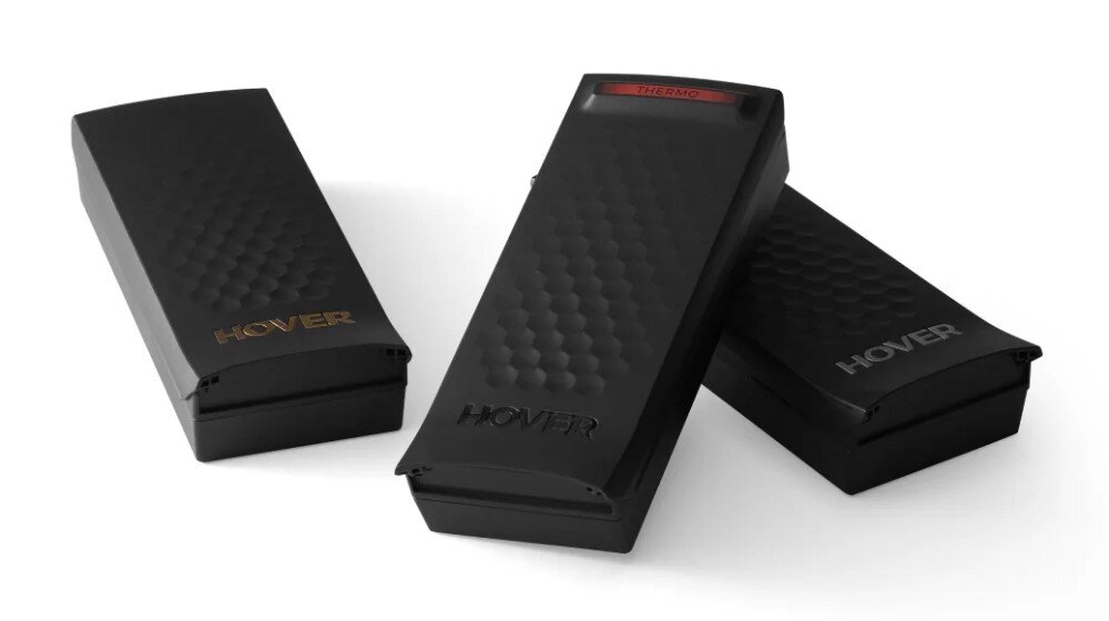 Akumulator HOVERAIR Smart do X1 Pro / X1 ProMax Kompozycja trzech czarnych urządzeń na białym tle, z których środkowe prezentuje u góry czerwony, podświetlony pasek z tekstem 'THERMO'