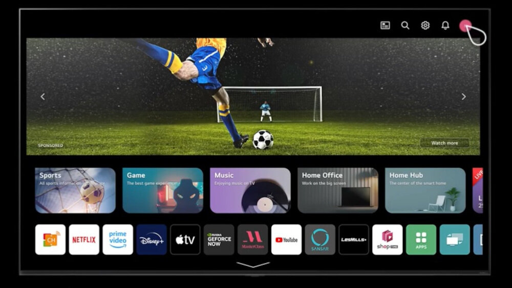 Ekran telewizora wyświetla interfejs z aplikacjami takimi jak Netflix, Prime Video, Disney+, Apple TV, YouTube i inne. W tle widoczna jest scena z meczu piłki nożnej z piłkarzem i bramkarzem na boisku.