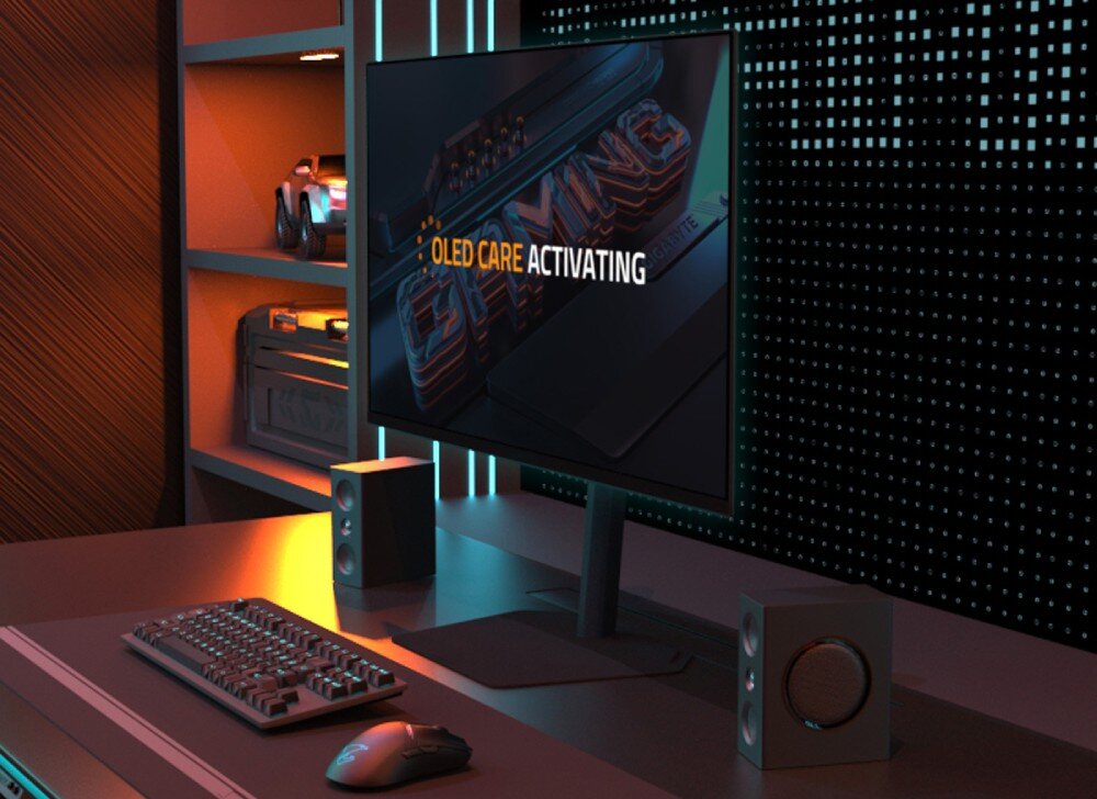 Monitor GIGABYTE MO27Q2 Biurko z monitorem, na którego ekranie wyświetlony jest komunikat 'OLED CARE ACTIVATING', ochrona matrycy, wypalenie
