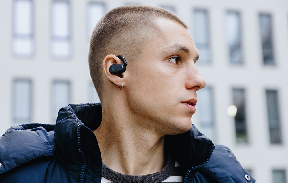 Słuchawki EDIFIER Comfo Flex otwarta konstrukcja wygodne użytkowanie, osoba z założonymi słuchawkami w mieście