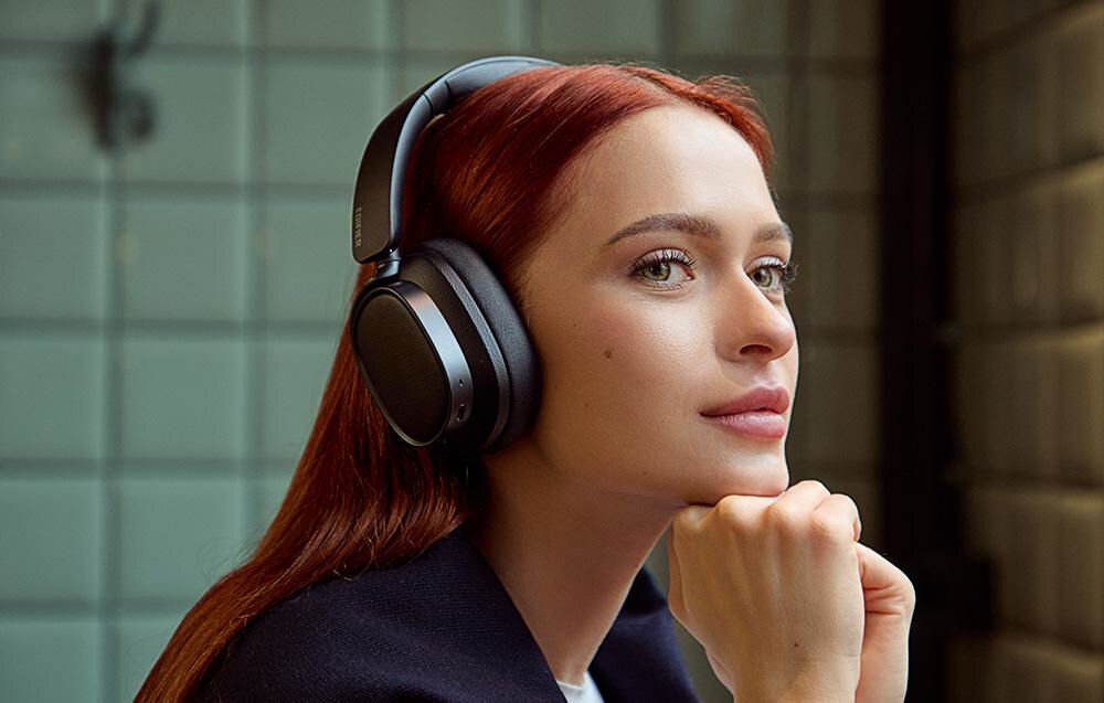 Słuchawki EDIFIER ES850NB ANC dwa mikrofony AI redukcja szumów czyste rozmowy Bluetooth, osoba z założonymi słuchawkami nausznymi