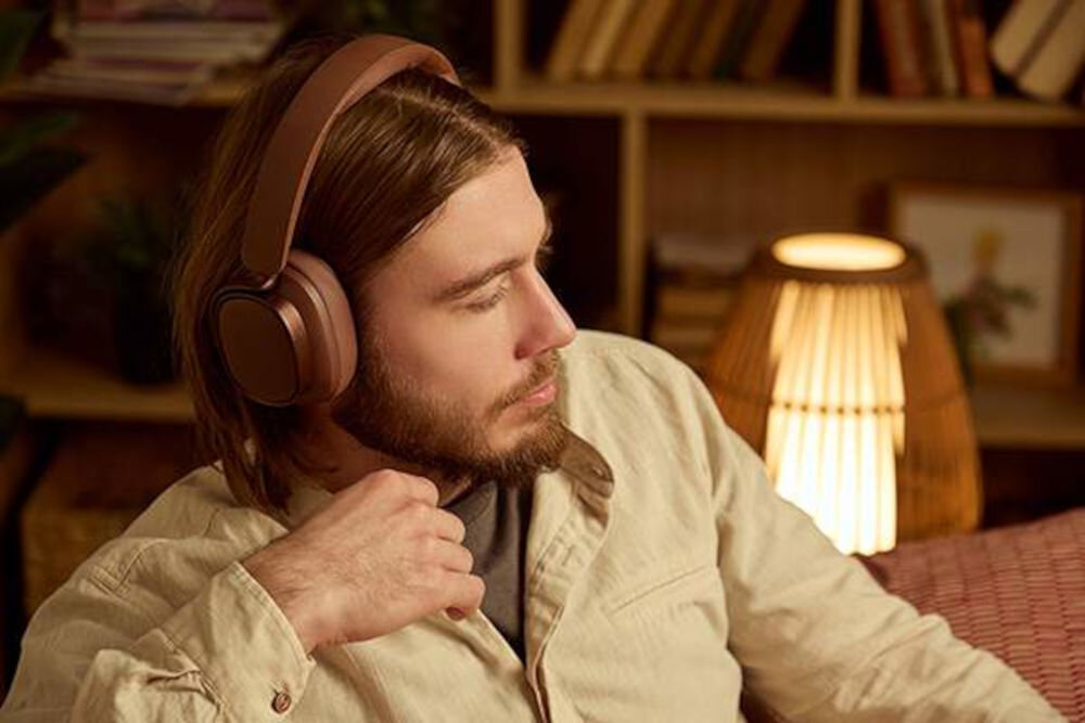 Słuchawki EDIFIER ES850NB ANC Bluetooth 5.4 multipoint connection Touch-to-chat przyciski silikonowe, osoba z założonymi słuchawkami nausznymi wsłuchana w muzyke