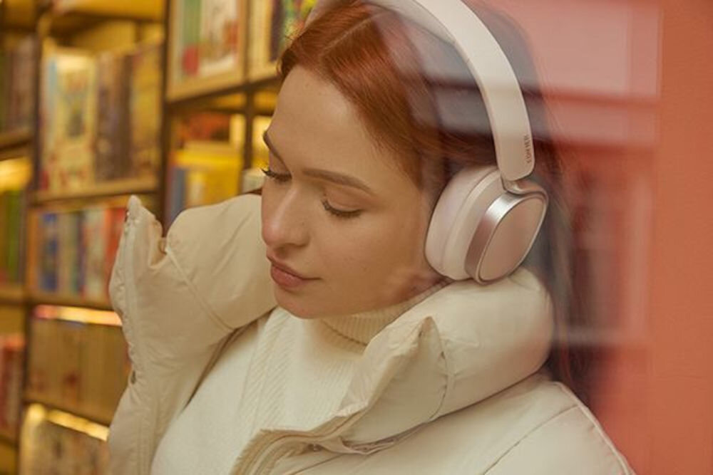 Słuchawki EDIFIER ES850NB ANC Bluetooth 5.4 multipoint connection Touch-to-chat przyciski silikonowe, osoba z założonymi słuchawkami nausznymi wsłuchana w muzyke