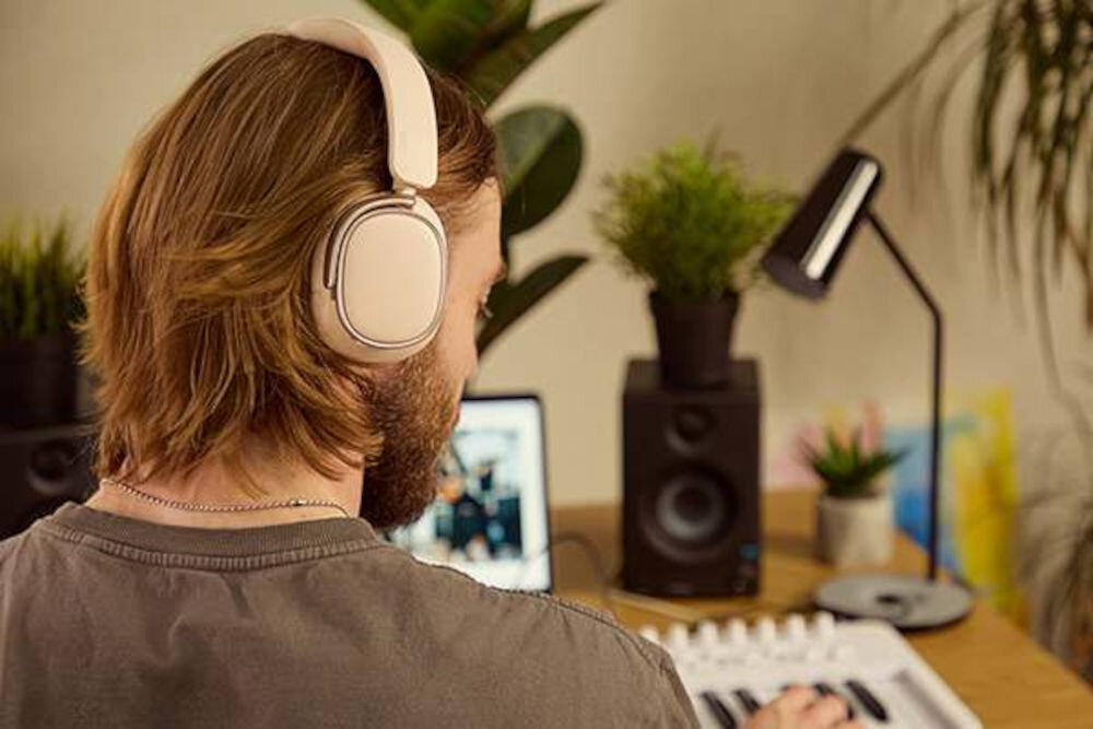 EDIFIER ES850NB ANC słuchawki Hi-Res Audio 40 mm tytanowa membrana LDAC SBC Bluetooth, osoba z założonymi słuchawkami nausznymi grająca na keyboardzie