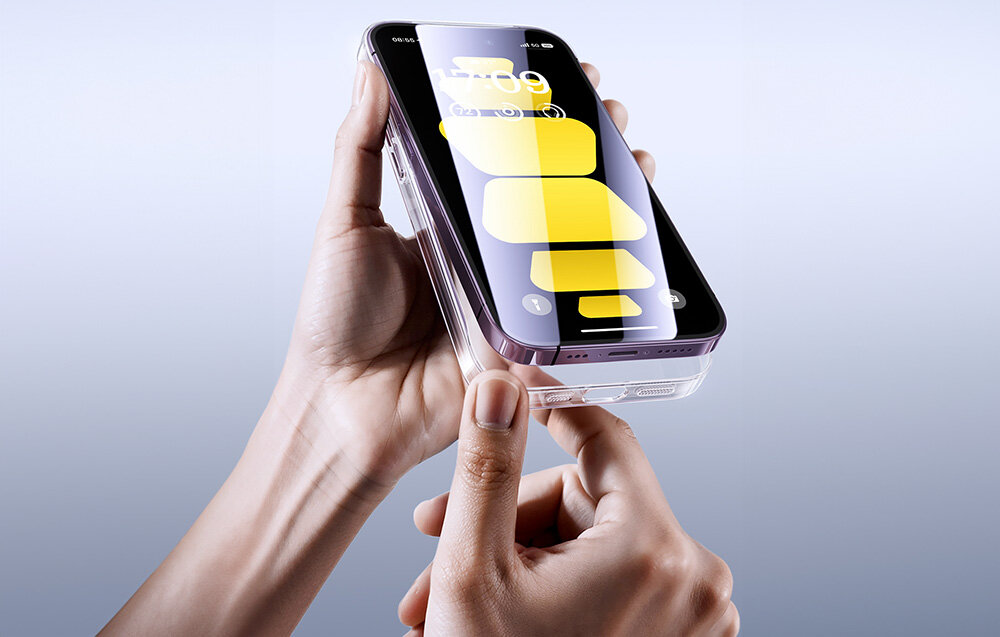 Osoba trzyma przezroczyste etui na telefon, w którym znajduje się smartfon z wyświetlonymi żółtymi ikonami na ekranie. Tło jest jednolite i jasne.