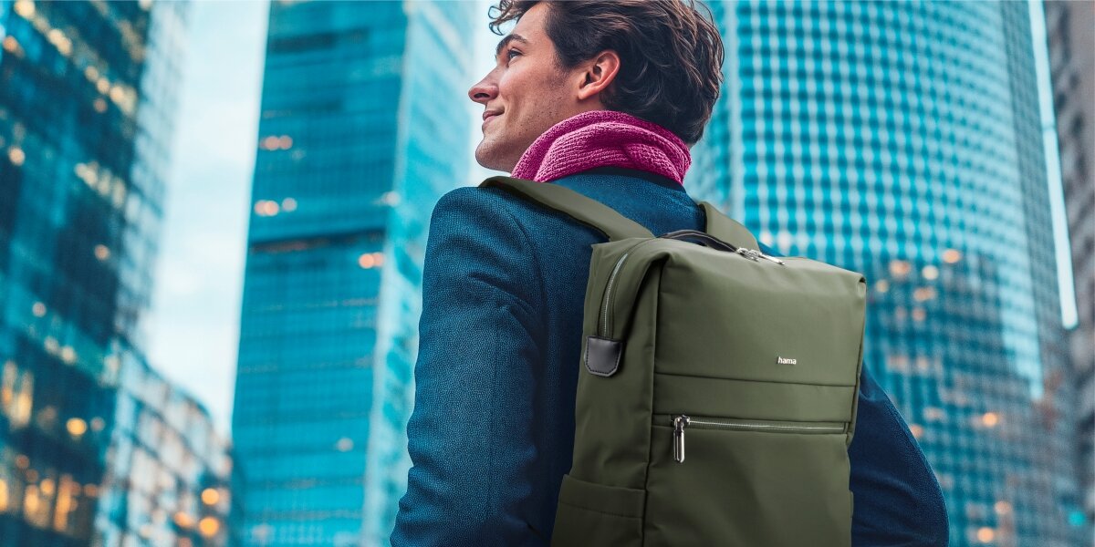 Plecak na laptopa HAMA Ultimate 16.2 cali Zielony Mężczyzna w garniturze niosący elegancki plecak na laptopa Hama na tle nowoczesnych wieżowców.