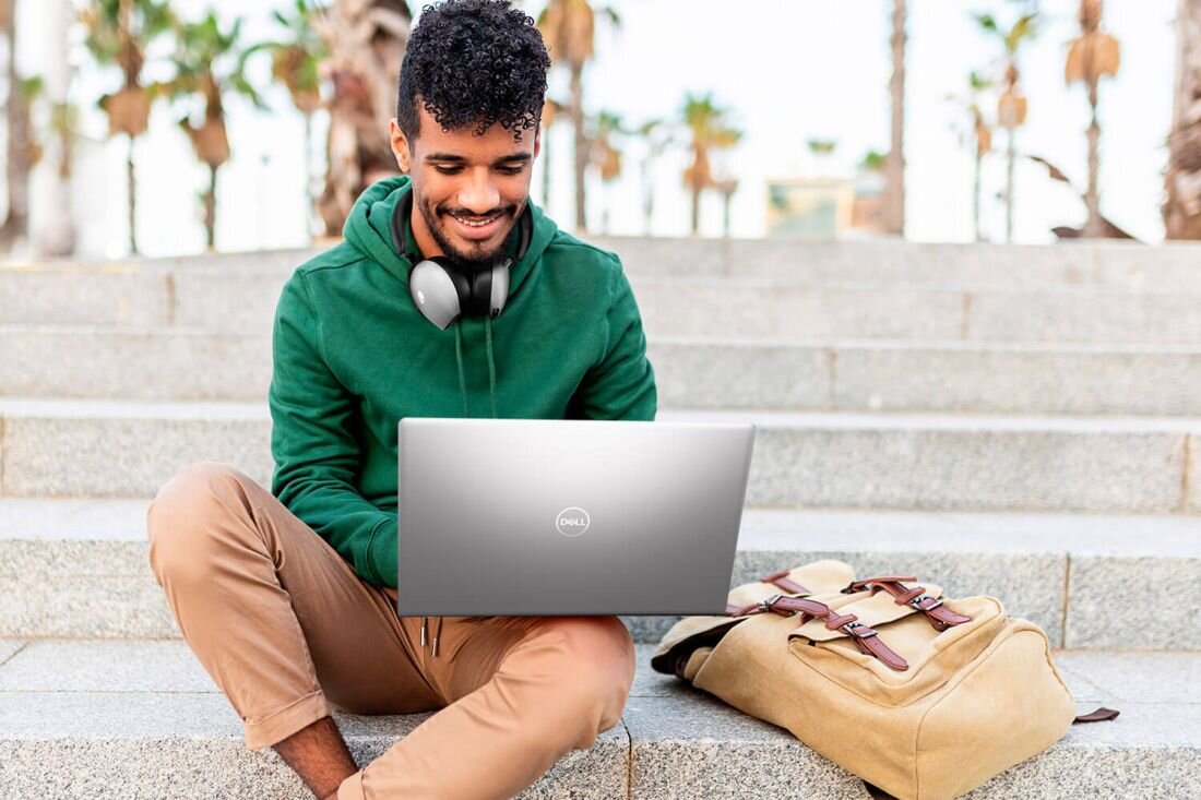Mężczyzna na schodach pracuje na laptopie DELL Inspiron 3530. - Szybka łączność Wi-Fi 6