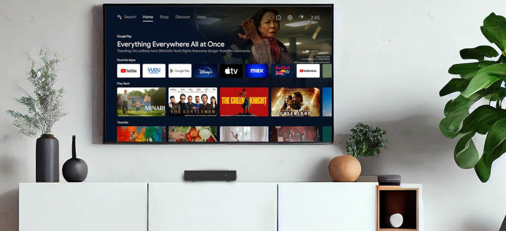 Odtwarzacz multimedialny 4K TESLA MediaBox XT850 do streamingu, TV naziemnej i internetu, urządzenie stojące na komodzie nad wiszącym telewizorem w pomieszczeniu