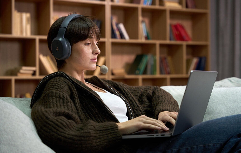 Słuchawki EDIFIER K750W przetworniki 40 mm mikrofony redukcja szumów, osoba z założonymi słuchawkami pracująca na laptopie, osoba z założonymi słuchawkami pracująca na laptopie