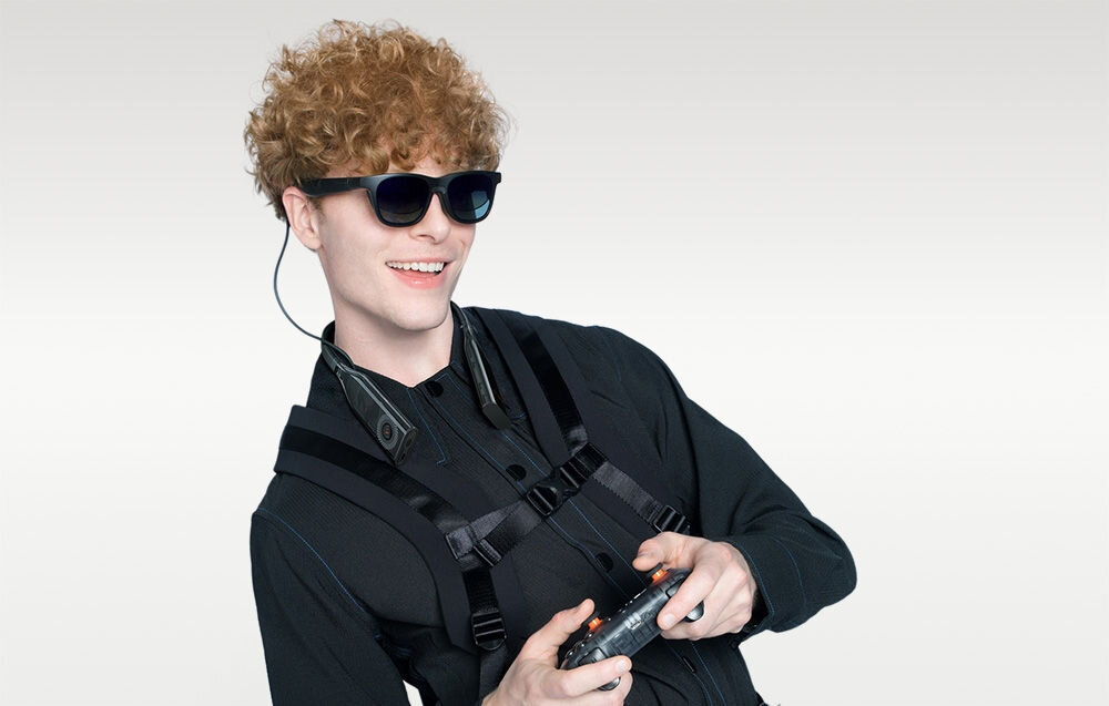 Opaska na szyję VITURE Pro NKBD 128GB Czarny chłopak z założoną opaską i okularami grający na padzie jasne tło