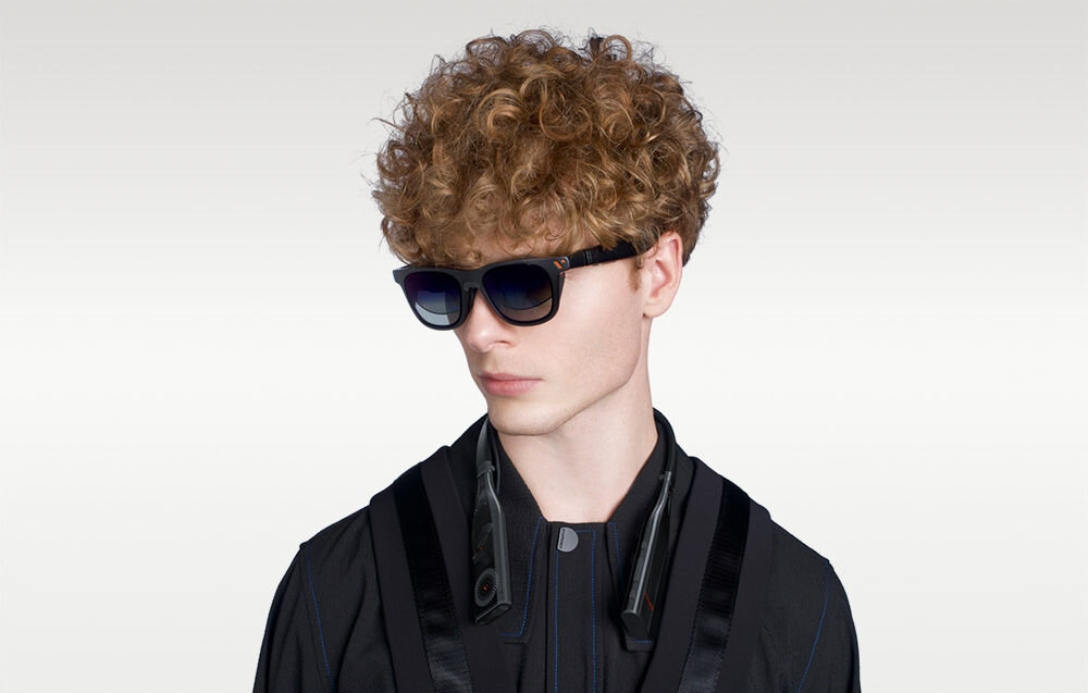 Opaska na szyję VITURE Pro NKBD 128GB Czarny chłopak z założoną opaską i okularami na jasnym tle wydajny akumulator ponad 4 godziny użytkowania podróż swoboda działania